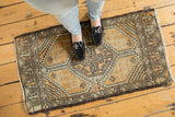 Vintage distressed Oushak rug with central hooked medallion and geometric panels.