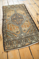 Corner of a distressed vintage Oushak rug with muted geometric patterns and worn pile texture.