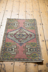 Distressed texture of the Oushak rug, showing stepped medallion and green plant motifs.
