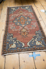 Distressed vintage Oushak runner corner with bronze field, slate gray motif, and tangerine accents.