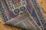 Distressed vintage Oushak rug corner, showing geometric patterns and hand-knotted foundation.