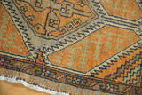 Vintage Distressed Oushak rug corner showing pale burnt orange and sand geometric motifs with wear.