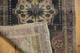 Folded Vintage Distressed Oushak rug, showing muted oxidized silver pile and pale woven reverse.