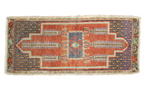Distressed Oushak rug with elongated ram's horn medallion, tree motifs, faded red, dusty blue.