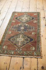 Distressed contours of a bronze, copper, and mint green medallion on a vintage Oushak rug.
