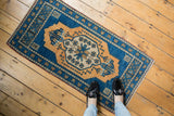 Stylized germinating plant and vine motifs on a distressed aqua blue and beige Oushak rug.