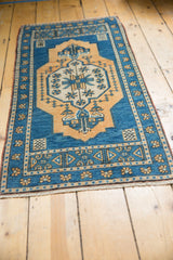 Vintage Distressed Oushak rug with aqua blue border, intricate floral motifs, and fringe.