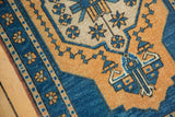 Distressed vintage Oushak border and field showcasing aqua blue and orange geometric motifs.