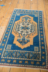 Lower border of distressed Oushak rug showing aqua blue floral cross section motif.
