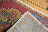 Hand-knotted construction and ivory fringe of the blush and gold distressed Oushak rug.