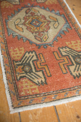Close-up of geometric field motifs in burnt orange, charcoal, and beige on a distressed Oushak rug.