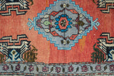 Distressed vintage Oushak rug with madder red field, grey stepped medallion, and floral border.