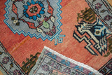 Vintage distressed Oushak rug showing brick red pile and hand-knotted fringe detail.