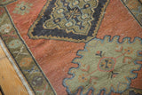 Vintage distressed Oushak rug, pale rust ground, charcoal medallion and mint green weaver nuances.