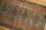 Distressed texture of vintage Oushak rug's geometric copper and antique ivory medallions.