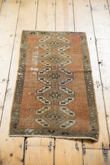 Close-up of distressed vintage Oushak rug corner, showing geometric pattern and storied texture.