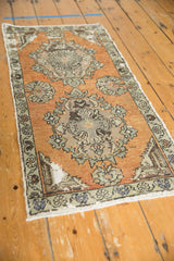 Distressed Oushak runner with terracotta field, Rococo medallion, and visible foundation wear.