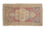 Dusty mauve and antique ivory distressed Oushak rug with a scalloped center medallion.