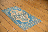 Geometric border patterns and distressed texture on a vintage Oushak rug corner.
