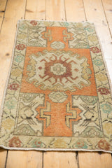 Upper corner of distressed Oushak rug, showing pale orange field and antique ivory germinating motifs.