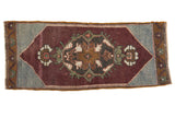 Distressed Oushak rug runner with central palmette medallion, aubergine and slate blue tones.