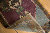 Distressed Oushak rug corner detail, revealing aubergine pile, foundation wear, and secured fringe.