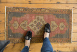 Upper right corner of a distressed vintage Oushak rug, blush rose field, ivory spandrel.
