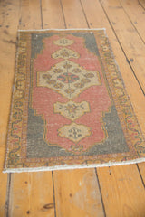 Distressed Oushak rug corner with dusty blush rose field, charcoal spandrel, gold border.
