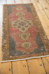 Distressed Oushak rug end detail, showing dusty blush rose wear and fringe.