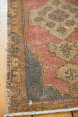 Worn texture and ivory fringe on the distressed Oushak rug's bottom corner.