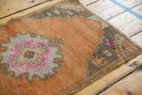 Vintage distressed Oushak rug corner, coffee brown border, fuchsia accents, worn orange field.