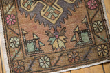 Distressed Oushak rug corner with pale coffee brown, rose pink, seafoam green, and slate motifs.