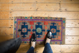 Triple medallion Oushak rug mat with navy, brick red, pistachio green geometric patterns.