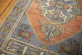 Textured apricot field with blossoming floral design and intricate slate blue stepped contour of the vintage Oushak rug.