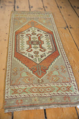 Distressed Oushak rug's left side showcasing tangerine and rust stepped medallion contour.