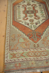 Decorative border of the distressed Oushak rug, featuring pale mint green and rust geometric motifs.