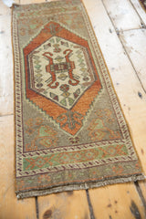 Distressed vintage Oushak rug end, showing short fringe and geometric pale mint green border.