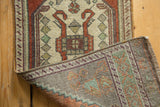 Distressed Oushak rug pile with tangerine, rust, and ivory geometric motifs showing hand-knotted reverse.