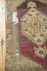 Detail of distressed Oushak rug with geometric finned floral motifs, hook border, and worn pile.