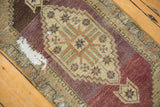 Distressed Oushak rug: exposed foundation from pile wear, aubergine, beige, and green geometric motifs.