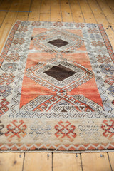 Textured distressed Oushak rug with pale blush diamond motif, zig-zag vine, and crab border.