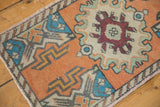 Distressed vintage Oushak rug showing burgundy germinating plant motif and even wear.