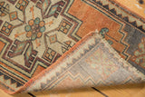 Distressed geometric pile, secured edge, hand-knotted foundation of vintage Oushak rug.