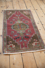 Vintage distressed Oushak rug close-up, highlighting even wear and faded burnt orange, bronze patterns.