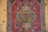 Distressed texture, burnt orange field, and bronze plant motif on a vintage Turkish Oushak rug.