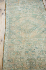 Worn pile of vintage distressed Oushak rug featuring faded green, beige floral motifs, secured edge.