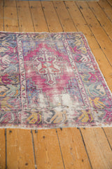 Expressive floral and leaf motifs on the distressed Oushak rug's wide border.