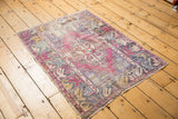 Vintage Oushak corner showing distressed aubergine and blue floral border.