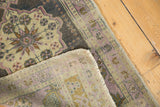 Distressed Oushak rug with ornate floral medallion, mauve border, and hand-knotted reverse.