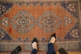 Vintage Distressed Oushak rug featuring an abrashed terra cotta field and geometric palmettes.